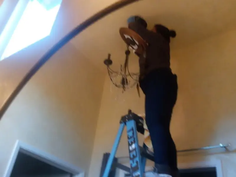 Electrician installing a chandelier in a Eldon residence
